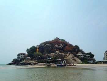 Scenic view of sea and buildings against clear sky