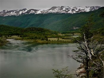 Scenic view of lake by mountains against sky