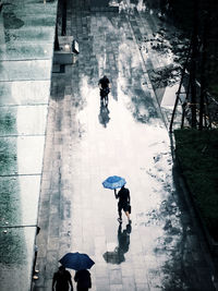 High angle view of people walking on wet street