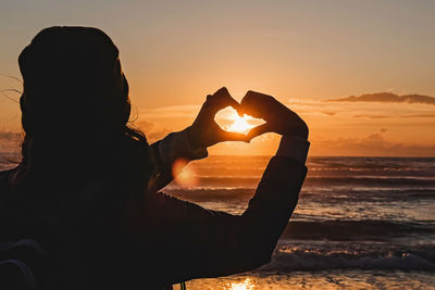 Silhouette woman standing at sunset