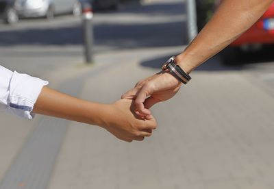 Cropped image of couple holding hands on street