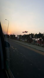 Road in city against sky during sunset