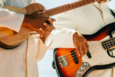 Close-up of hands holding guitars