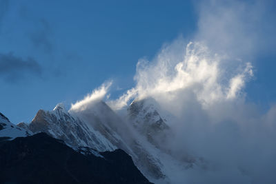 Low angle view of snowcapped mountains against sky