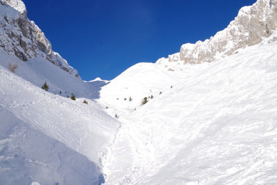 Scenic view of snowcapped mountains against blue sky