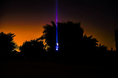 Low angle view of silhouette trees against sky at night