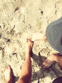 Low section of man and woman standing on beach