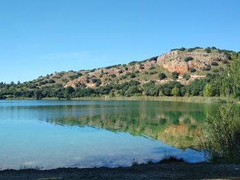 Scenic view of lake against clear blue sky