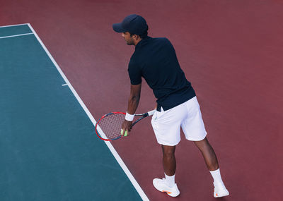 Rear view of man playing tennis