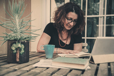 Woman sitting on table at home