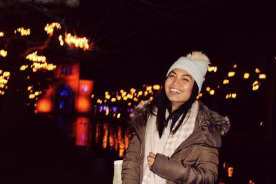 Portrait of smiling woman standing at night