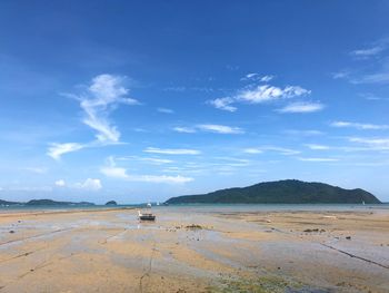 Scenic view of beach against blue sky