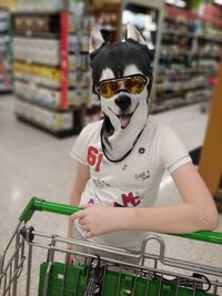 Portrait of boy standing against store