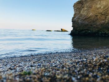 Surface level view of beach against clear blue sky