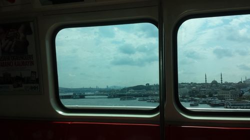 Close-up of cars against sky seen through window