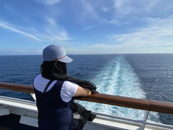 Rear view of person looking at sea against sky