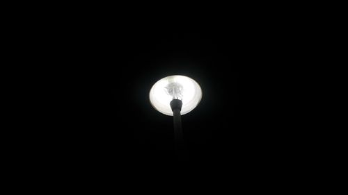 Low angle view of illuminated street light against dark sky