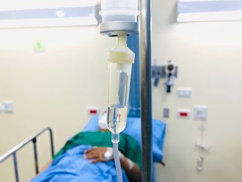 Midsection of man with arms raised on bed