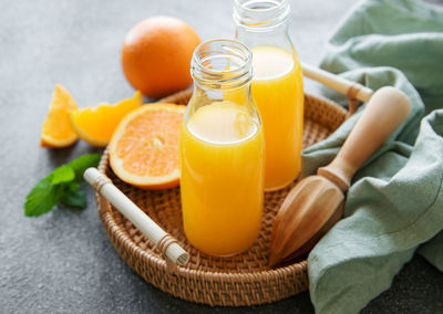 Bottles of fresh orange juice with fresh fruits