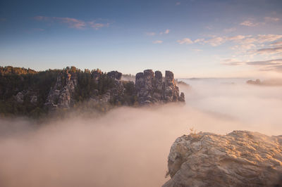 Rock formations by sea against sky