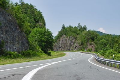 Road amidst trees against sky