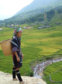 Full length of woman standing on field against sky