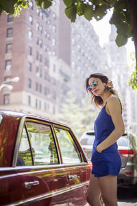 Fashionable woman standing near vintage car