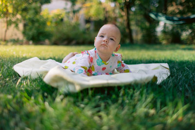 Portrait of cute baby boy sitting on grass