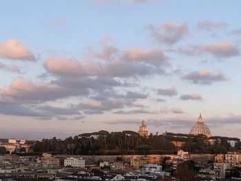 Buildings in city against sky during sunset