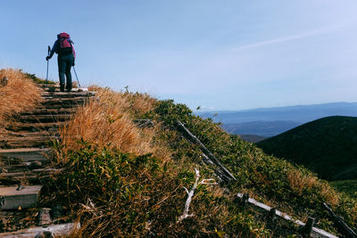 Rear view of man on mountain against sky