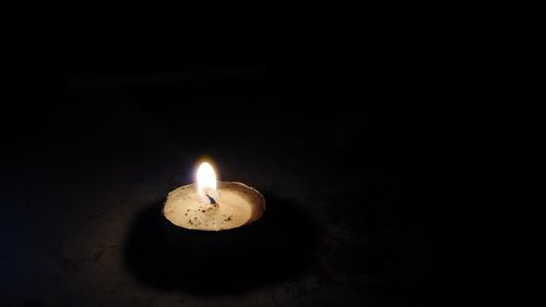 Lit candle in dark room