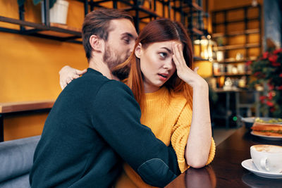 Young couple sitting on table