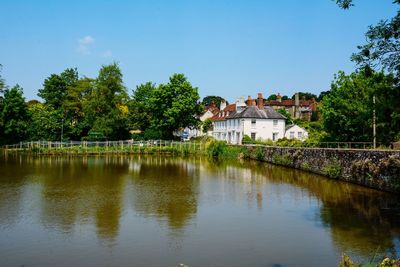 Scenic view of lake by buildings against sky