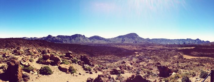 Panoramic view of landscape and mountains against blue sky