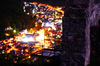 High angle view of illuminated street by buildings at night