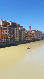 Boats in river with buildings in background