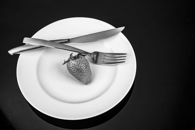 High angle view of eggs in plate against black background