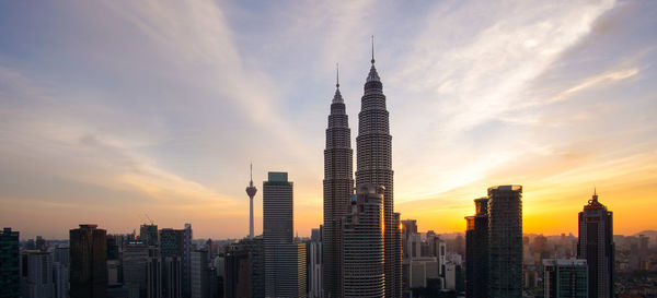 Skyscrapers in city against cloudy sky