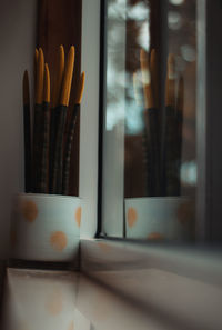 Close-up of incense stick by window at home