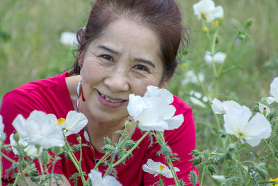 Portrait of smiling woman with red flower