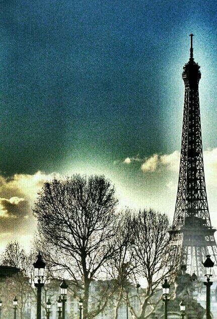 built structure, architecture, tower, building exterior, sky, low angle view, tall - high, cloud - sky, tree, bare tree, travel destinations, cloudy, international landmark, famous place, communications tower, eiffel tower, city, no people, cloud, history