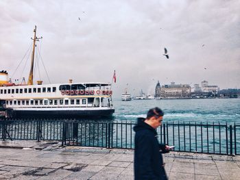 Woman looking at harbor against sky