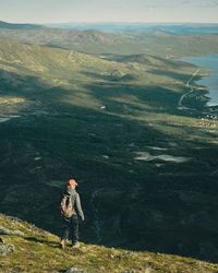 Rear view of woman with backpack walking on mountain