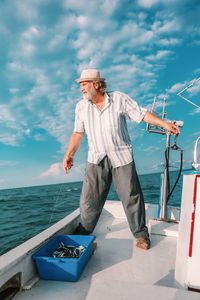 Man standing in sea against sky