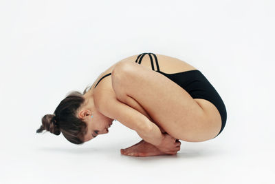 Side view of young woman against white background
