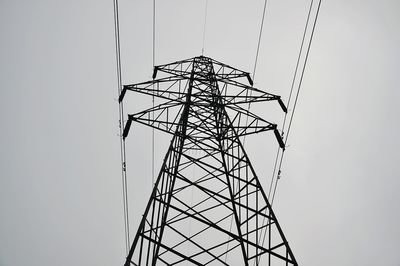 Low angle view of electricity pylon against clear sky