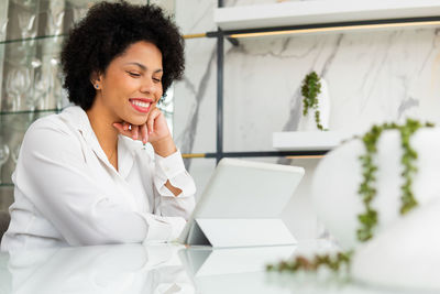 Young woman looking down while sitting on table