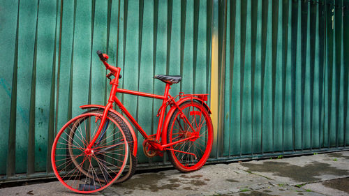 Broken bicycle parked against wall