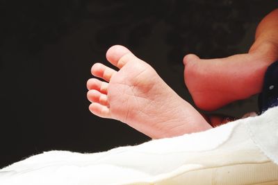 Close-up of baby hand against black background