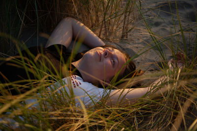 Close-up of smiling woman lying on field